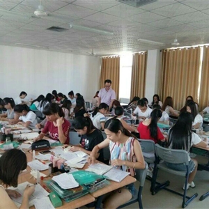 图为农老师指导会计专业学生在进行会计综合实训